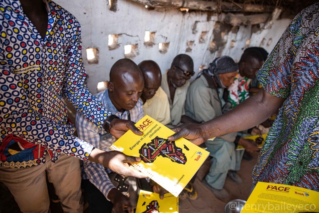 Community members reading Pan African Conservation Education (PACE) book, Environment Sahel project work in Chad.