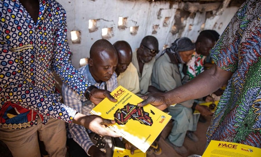 Community members reading Pan African Conservation Education (PACE) book, Environment Sahel project work in Chad.